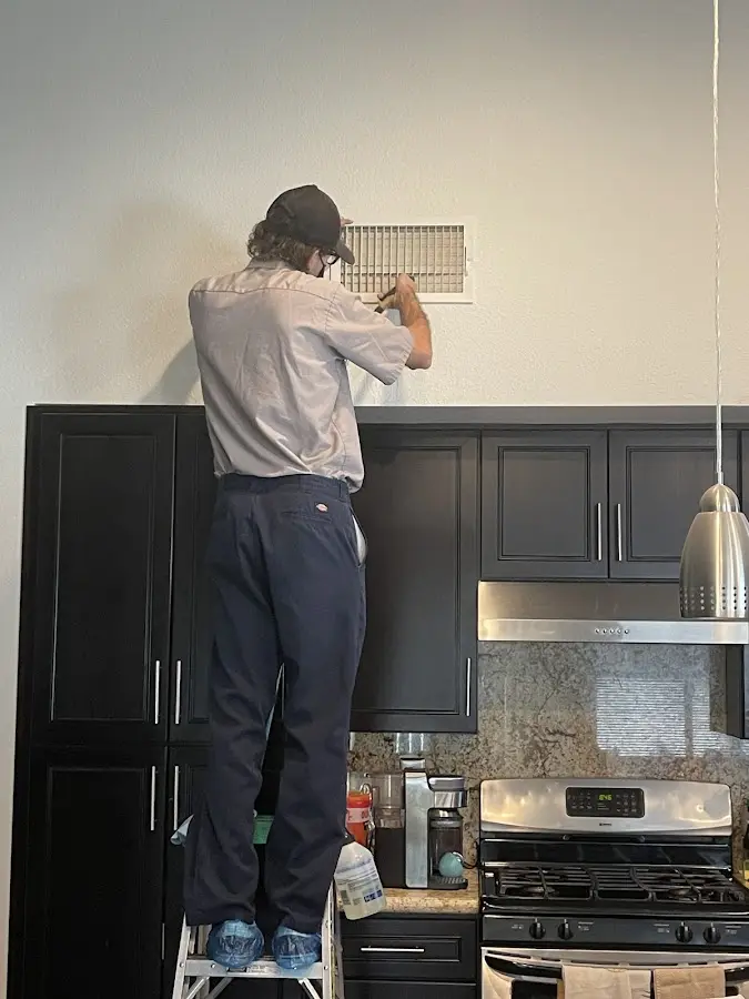 Technician inspecting an air vent during HVAC service in Uniontown